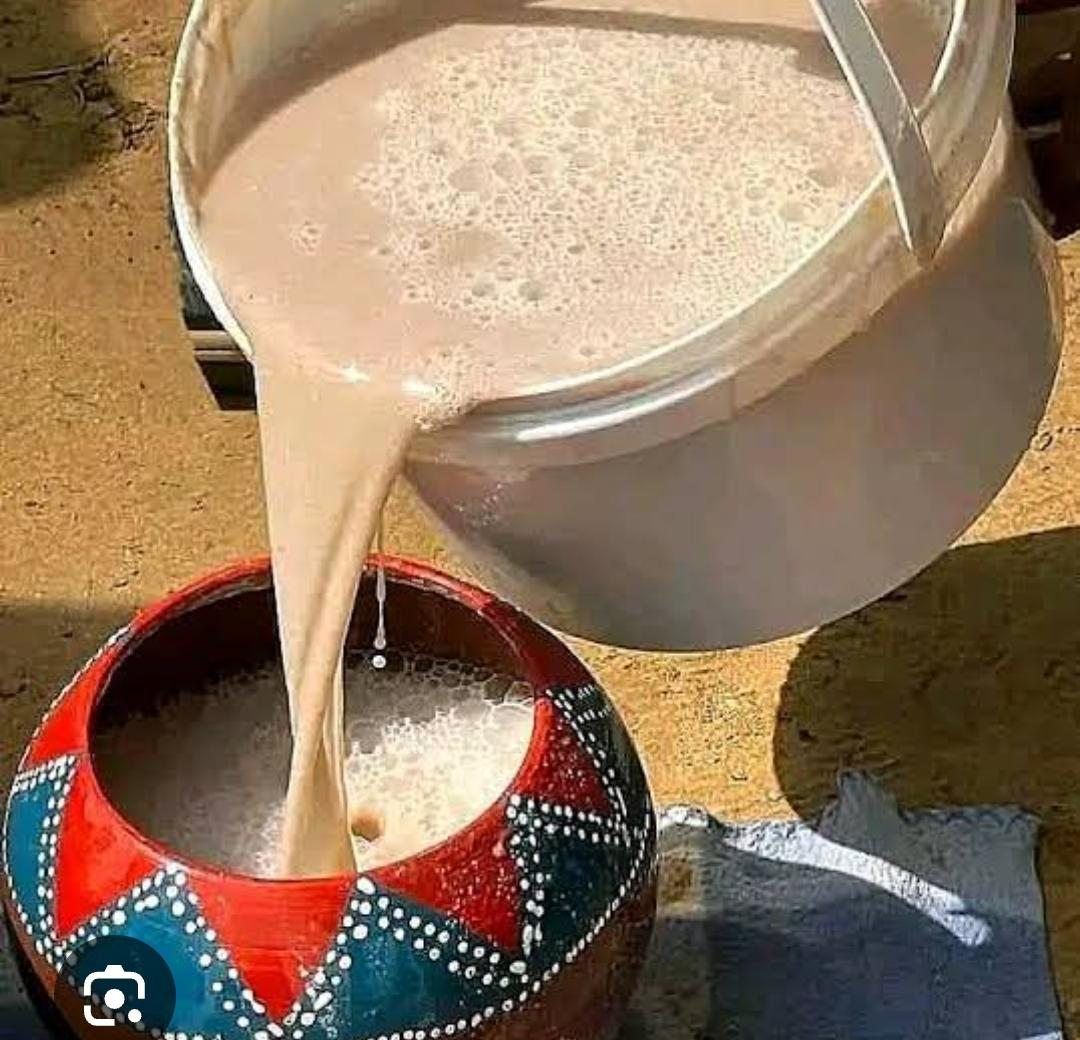 Traditional sorghum beer being poured into a decorated clay pot